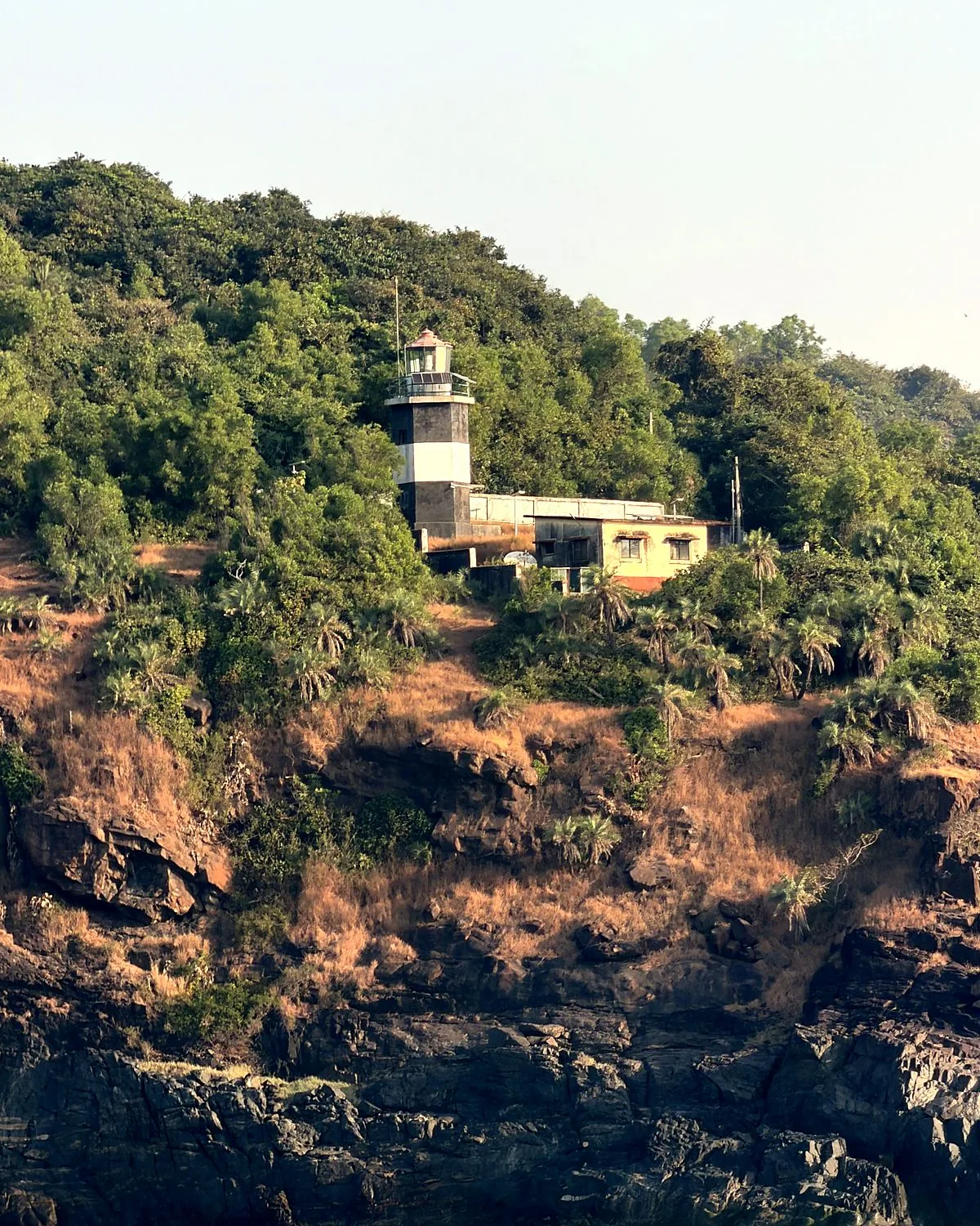 Gokarna lighthouse on the green headland, seen from the boat